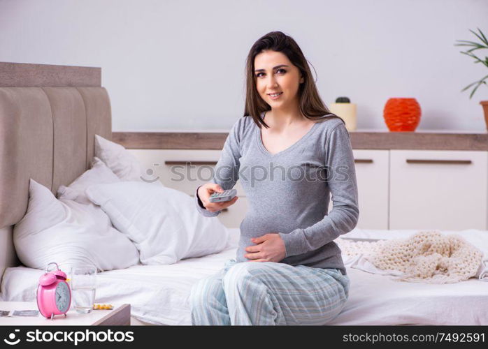 The young pregnant woman in the bedroom. Young pregnant woman in the bedroom