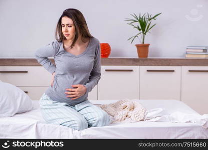 The young pregnant woman in the bedroom. Young pregnant woman in the bedroom