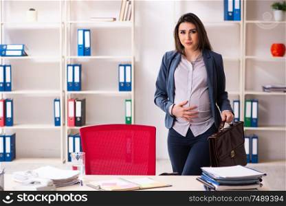 The young pregnant woman working in the office . Young pregnant woman working in the office