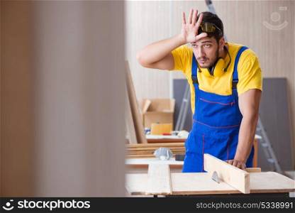 The young repairman carpenter working cutting wood on circular saw. Young repairman carpenter working cutting wood on circular saw