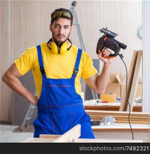 The young repairman carpenter working cutting wood on circular saw. Young repairman carpenter working cutting wood on circular saw