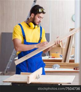 The young repairman carpenter working cutting wood. Young repairman carpenter working cutting wood