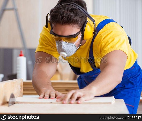 The young repairman carpenter working with a circular saw. Young repairman carpenter working with a circular saw
