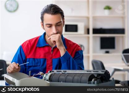 The young repairman repairing air-conditioner at warranty center. Young repairman repairing air-conditioner at warranty center