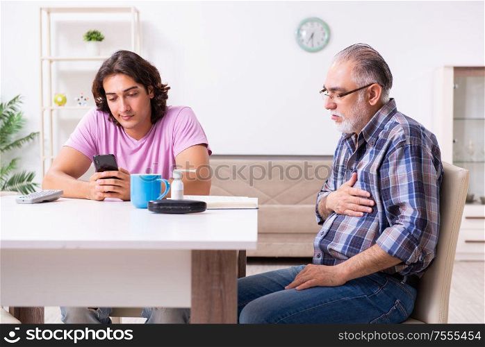 The young student and his old grandpa at home. Young student and his old grandpa at home
