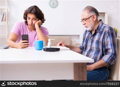 The young student and his old grandpa at home. Young student and his old grandpa at home