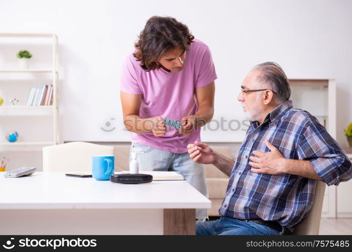 The young student and his old grandpa at home. Young student and his old grandpa at home