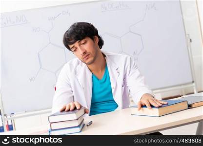 The young student chemist in the classroom . Young student chemist in the classroom 