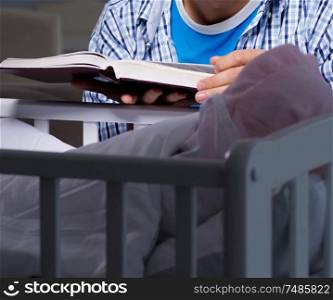 The young student doing homework and looking after newborn baby. Young student doing homework and looking after newborn baby