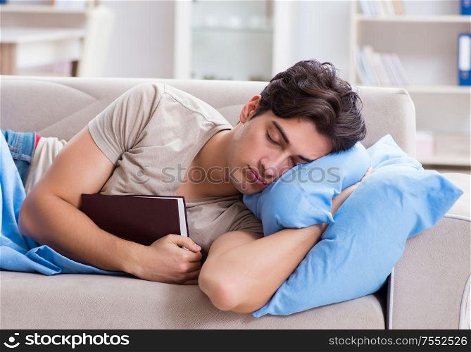 The young student man preparing for college exams in bed with book. Young student man preparing for college exams in bed with book