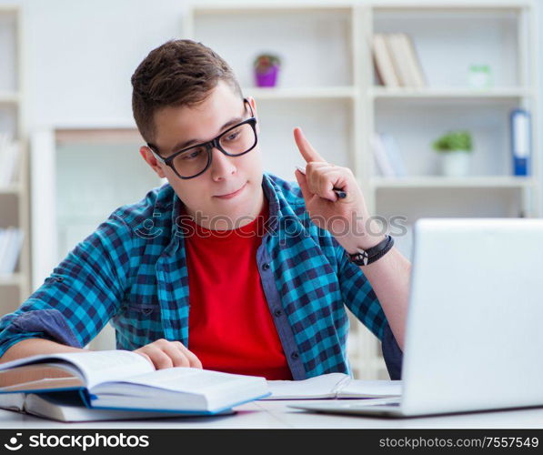 The young teenager preparing for exams studying at a desk indoors. Young teenager preparing for exams studying at a desk indoors