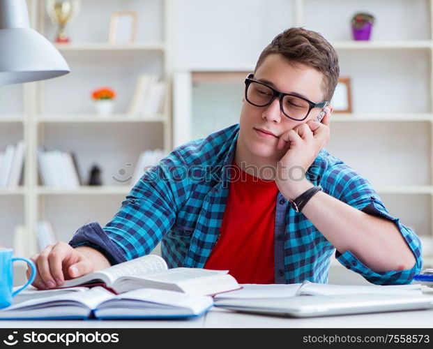 The young teenager preparing for exams studying at a desk indoors. Young teenager preparing for exams studying at a desk indoors