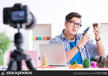 The young vlogger recording video doing christmas decoration. Young vlogger recording video doing christmas decoration