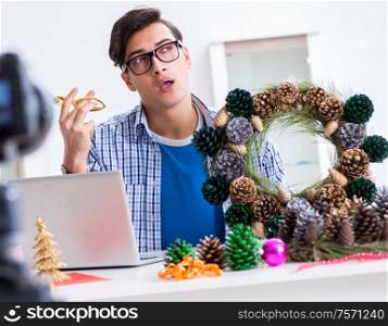 The young vlogger recording video doing christmas decoration. Young vlogger recording video doing christmas decoration