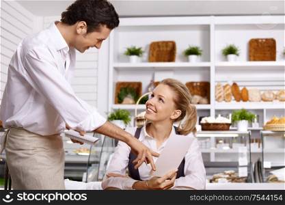 The young waiter advises to the girl a dish choice