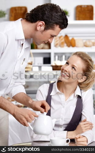 The young waiter with the client in cafe