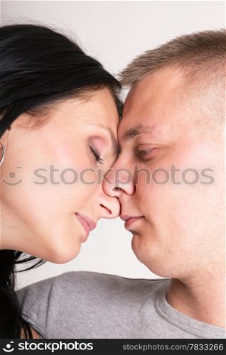 The young woman and the man in passionate embraces couple gray wall