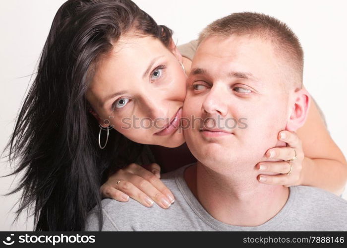 The young woman and the man in passionate embraces couple gray wall