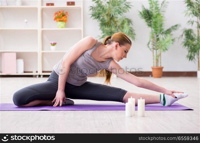 The young woman exercising in sports hall in healthy concept. Young woman exercising in sports hall in healthy concept