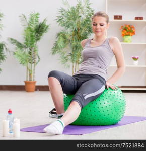 The young woman exercising with stability ball in gym. Young woman exercising with stability ball in gym