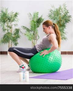 The young woman exercising with stability ball in gym. Young woman exercising with stability ball in gym