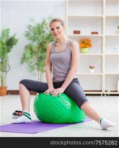 The young woman exercising with stability ball in gym. Young woman exercising with stability ball in gym