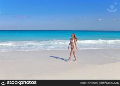 The young woman goes on a beach at sea edge