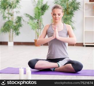 The young woman in lotus pose meditating in spa gym. Young woman in lotus pose meditating in spa gym