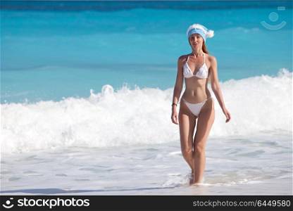 The young woman in the New Year&rsquo;s cap walks on a beach