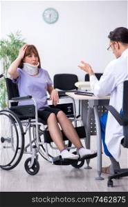 The young woman in wheel-chair visiting male doctor . Young woman in wheel-chair visiting male doctor 