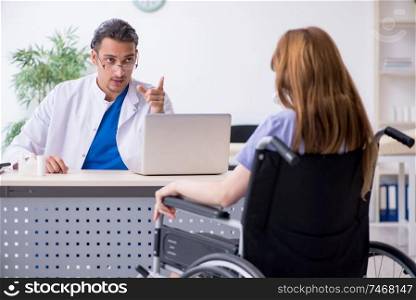 The young woman in wheel-chair visiting male doctor . Young woman in wheel-chair visiting male doctor 