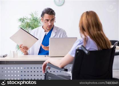 The young woman in wheel-chair visiting male doctor. Young woman in wheel-chair visiting male doctor