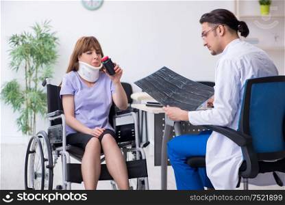 The young woman in wheel-chair visiting male doctor. Young woman in wheel-chair visiting male doctor