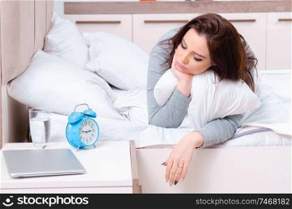 The young woman lying on the bed in time management concept . Young woman lying on the bed in time management concept 