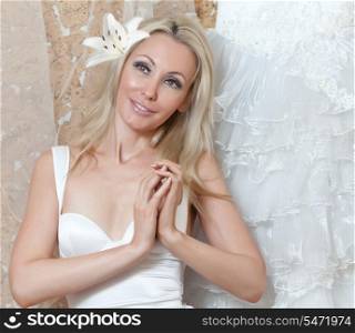 The young woman near to a wedding dress dreams of wedding
