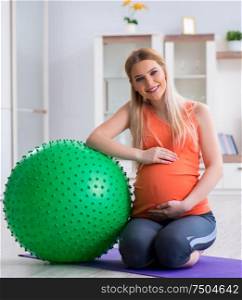 The young woman preparing for birth exercising at home. Young woman preparing for birth exercising at home