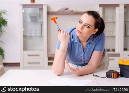 The young woman repairing chair at home . Young woman repairing chair at home 