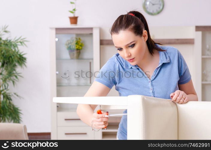 The young woman repairing chair at home . Young woman repairing chair at home 