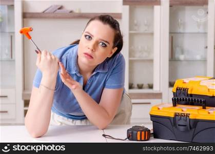The young woman repairing chair at home . Young woman repairing chair at home 