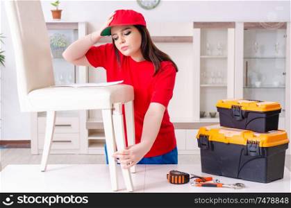 The young woman repairing chair at home . Young woman repairing chair at home