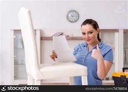 The young woman repairing chair at home . Young woman repairing chair at home