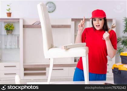 The young woman repairing chair at home. Young woman repairing chair at home