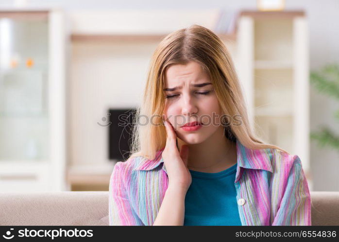 The young woman suffering with pain at home. Young woman suffering with pain at home