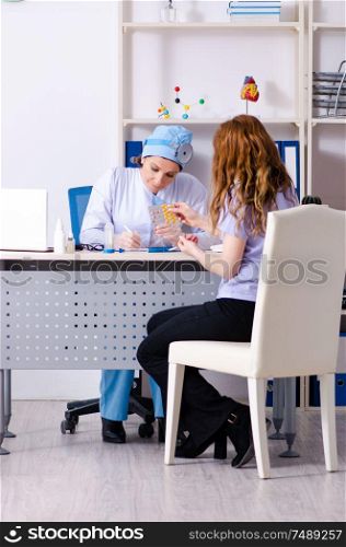 The young woman visiting female doctor otolaryngologist. Young woman visiting female doctor otolaryngologist