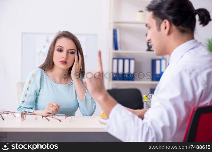 The young woman visiting male doctor oculist . Young woman visiting male doctor oculist