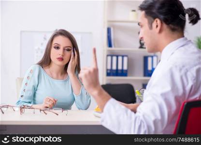 The young woman visiting male doctor oculist . Young woman visiting male doctor oculist