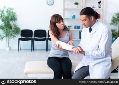 The young woman visiting male doctor traumatologist. Young woman visiting male doctor traumatologist