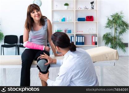 The young woman visiting male doctor traumatologist. Young woman visiting male doctor traumatologist