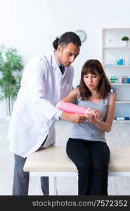 The young woman visiting male doctor traumatologist. Young woman visiting male doctor traumatologist