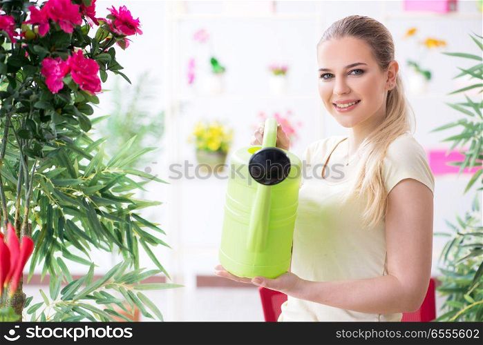 The young woman watering plants in her garden. Young woman watering plants in her garden
